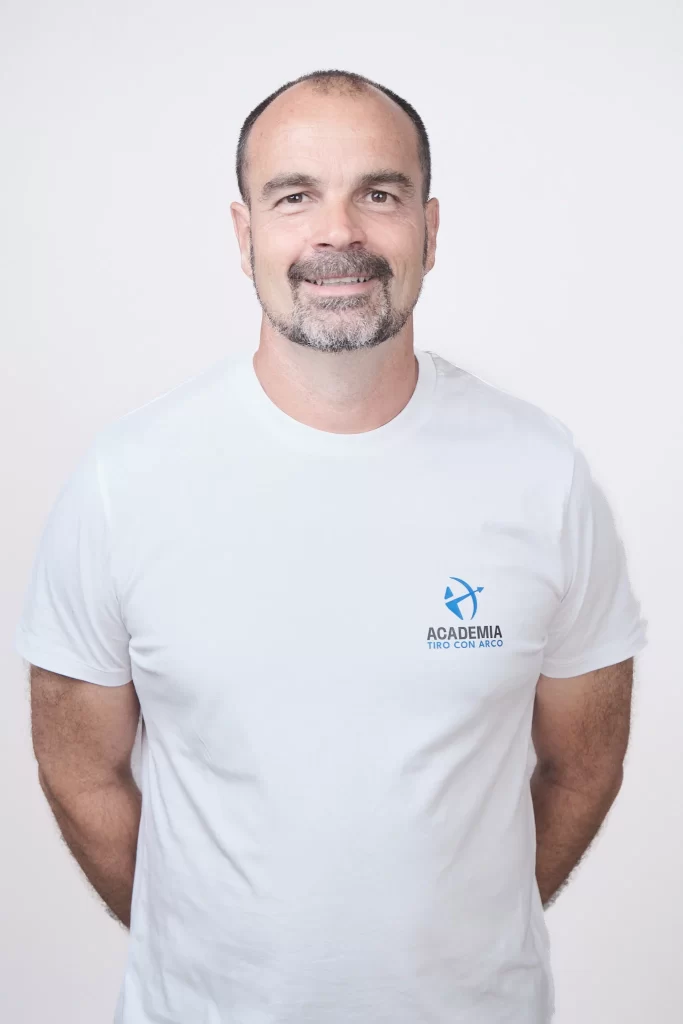 Foto de hombre con camiseta de Academia Tiro con Arco, posando de forma profesional en un estudio fotográfico.