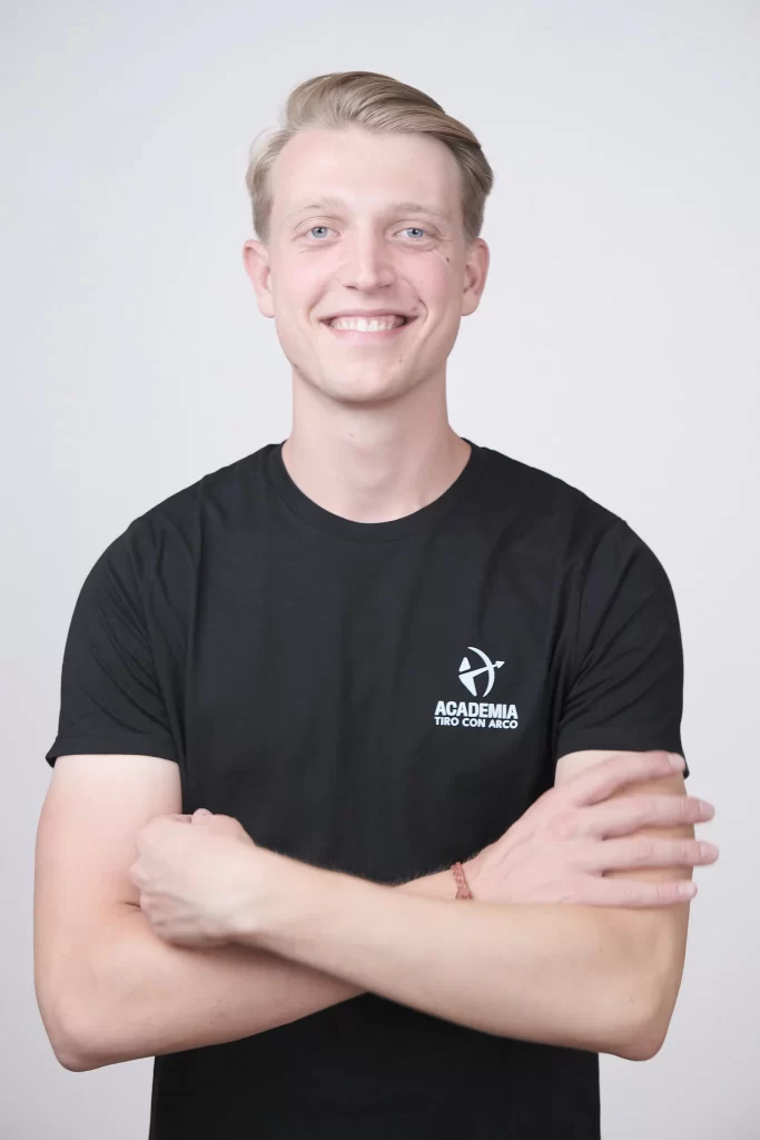 Retrato de hombre joven con camiseta de Academia Tiro con Arco, posando para sesión de fotos en estudio