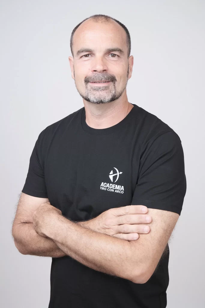 Fotografía de hombre con camiseta de Academia Tiro con Arco, en sesión de retrato en estudio profesional.